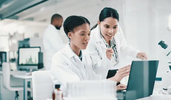 Two laboratory employees looking at a screen