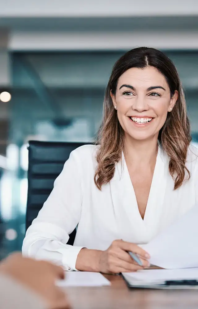 Woman smiling in a office holding a piece of paper