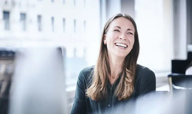 Happy woman at her work station in the office
